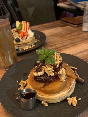 Pancakes with dates, walnuts, cinnamon stewed apples and maple syrup (€12,00) and an iced caramel latte with oat milk (€5,60; €4,70 + €0,90 for oat, soy or almond milk…) at Mr NonNo - Center in Rotterdam