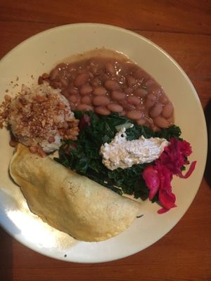 Veggie blend taco w/ guac., pinto beans, rice topped with crushed almonds, blanched greens and pickled veggies at Casa de Luz in Austin