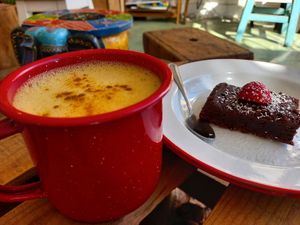 Golden Milk: oat milk, curcuma (turmeric plant), ginger, lemon, cinnamon & black pepper (on the left)! Vegan chocolate brownie (on the right)! at Roots in Aljezur