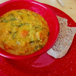 Red lentil, carrots, butternut squash and chard smoked paprika soup + slice of home-made Vegan bread. at Roots in Aljezur