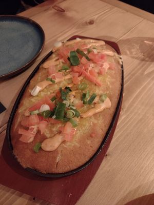 Corn bread in cast iron pan with vegan cheese on top at Source in York