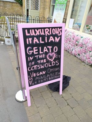 Outside sign showing Vegan options 🙂 at Fairy Gelato & Cakes Lora Nova in Bourton-on-the-water