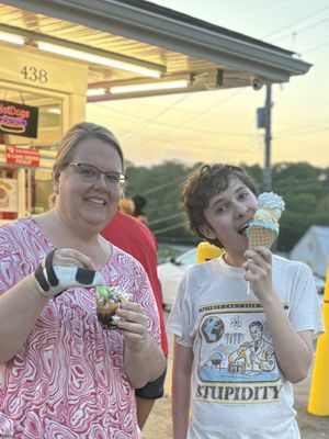 Small peanut butter chocolate sundae on the left, and soft serve blue raspberry/hard serve strawberry banana/vegan whipped cream ALL in a waffle cone on the right  at Skoops Ice Cream in Barberton