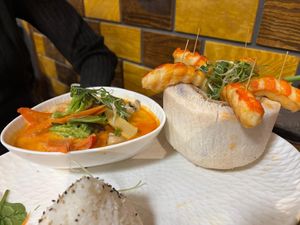 Vegane Riesengarnelen in einer Kokosnuss serviert,dazu Reis Thai Curry Sauce und Wildkräuter Salat at Loi Xua in Speyer
