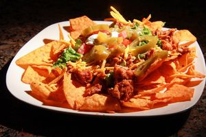 Jackfruit nachos with romaine, diced toma tomatoes, vegan sour cream, jalapeños and vegan cheese on a bed of vegan Doritos. at The Alkaline Electric Goddess in Indianapolis