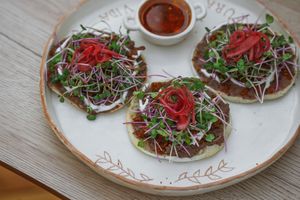 Vegan Cassava sopecitos 
vegan oatmeal chorizo, beans, vegan cream, vegan cheese, radish sprouts
 at Prana Café in Cancun