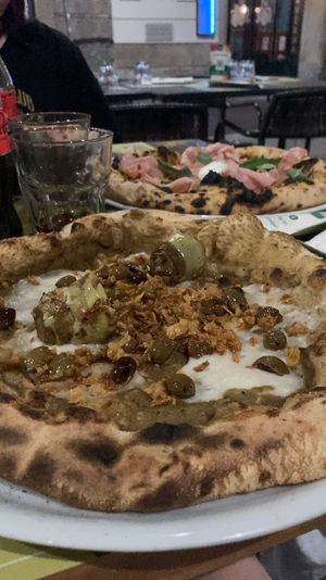 vegan pizza with artichokes, olives, vegan cheese, fried onions (and non veg pizza in the back)  at Organic Pizza & Food in Milan