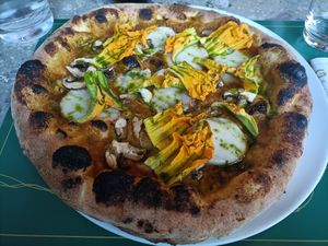 Pizza con crema di zucca, mozzarella di riso, funghi e fiori di zucca at Organic Pizza & Food in Milan