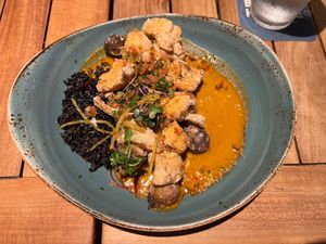 Aloo gobi main (second course) with delicately crisp cauliflower and marble potatoes, coconut purple rice, and curry sauce at Beach House by Roy Yamaguchi in Kahuku
