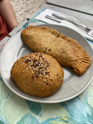 Black, being mushroom empanada. Also, quinoa, olive, and vegan cheese roll.  at Pimpinelas Coffe Shop Vegetariano in Santa Cruz Madeira