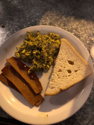Vegan Scramble w/ bacon and toast. Not super flavorful but still good  at Downbeat Diner and Lounge in Honolulu