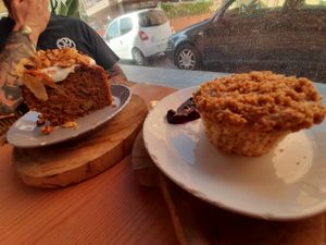 Carrot cake with frosting and banana muffin with crumbles at Sama Sama Veggie in Salou