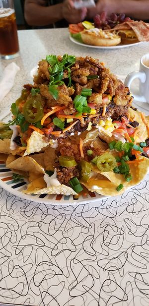 Nachos and the burger in the background at Spiral Diner & Bakery in Fort Worth