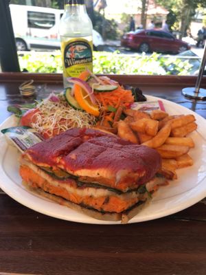Slice of vegan lasagna with chips and salad at Shali's Cafe in Montville
