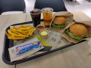 Zwei Burger mit Beyond Chicken und extra Käse, dazu eine Cola, einen Eistee, eine große Portion Pommes mit Ketchup und Mayo und zum Nachtisch einen Schokoriegel mit Karamell und  at VINCENT - Hauptbahnhof Hamburg in Hamburg