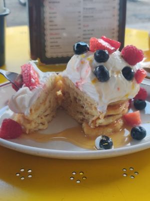 Vegan pancakes with coconut whipped cream, berries and lemon zest at The Breakfast Club - London Bridge in South East London