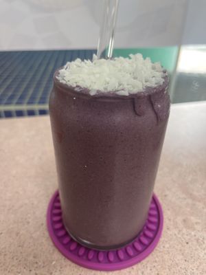 Purple Haze smoothie with freshly grated coconut. Glass straw too!  at Crisp in Roatan