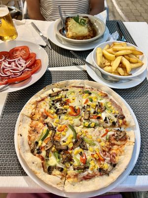 Vegan pizza, vegan lasagna tomato and onion salad and chips  at Louro & Salsa in Albufeira