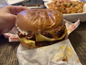 Mushroom burger and loaded tots in the back   at Project Pollo in Houston