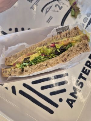 Sandwich with avocado, hummus, pomegranate at AMS - Amsterdam Bread Company in Schiphol