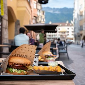 Swing Burger and Nuggets at the outdoor dining area (Background: Goldenes Dachl) at Swing Kitchen in Innsbruck