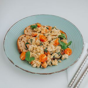 Scrambled organic tofu with cherry tomatoes, spinach and onion, served on 2 slices of rustic sourdough bread.
 at Color Nativo in Puerto Varas