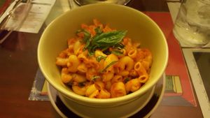 House-made vegan + gluten free mac 'n' cheese - corn pasta, sauce made from tomato and mango, topped with basil at Peace n Loaf in San Juan