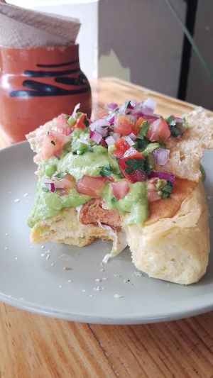 Salchicha cubierta con queso gratinado, salsa mexicana tipo guacamole y chicharrón at Mictlan Antojitos Veganos in Mexico City
