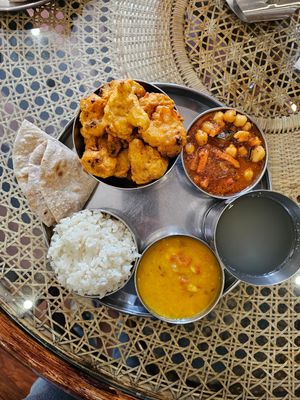 Daal, chickpea in tomato sauce, cauliflower in batter deep-fried, rice, lemon and ginger drink, and Chapatti at Govindas in Almaty