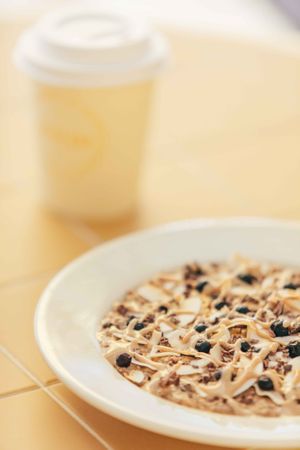 PB BANANA OVERNIGHT OATS - topped with frozen blueberries, coconut flakes, cocoa nibs and peanutbutter date caramel drizzle at Banacado in Stockholm