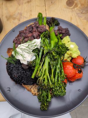 Vegan breakfast plate including broccoli, guacamole, vegan stracciatella, black bean mole, flat mushroom and roast tomato at Common Ground in North London