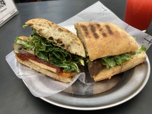 Sandwich en ciabatta de masa madre con hongos confitados, tomates secos, calabaza asada, tapenade de aceitunas, hojas verdes y tofu.    at Fifi Almacén in Buenos Aires