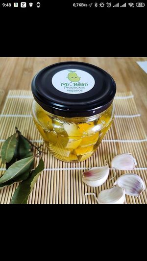 Queso vegano de elaboración propia en conserva de aceite, adornado por ajoas y hojas de laurel. at Veggie Bean in Mallorca