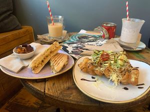 Vegan cheese and onion chutney panini and “the vegan one” waffle. Oat milk pumpkin spiced iced coffees at the back    at ComiCoffee in Newport