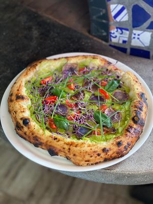 Pizza specială vegană cu cremă de zucchini, cartofi mov feliați, roșii cherry, germeni de ridichi, arpagic, busuioc și ulei de măsline.  at Pizzeria Da Ciro in Nasaud