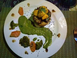 Sweet potatoes baked with pineapple and fresh made almond milk and cinnamon, topped with oven roasted veggies and a sauce made of basil, mint, cilantro, parsley garlic & tamari at Waterfall Villas in Dominical