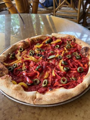 Pizza with red sauce, green olives, and bell peppers  at Hana Farms in Hana
