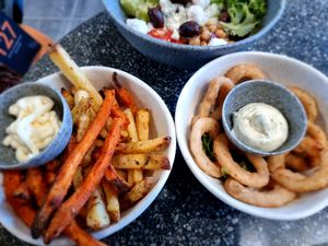 Fries and fried onion rings as sides at Copper Branch in Utrecht