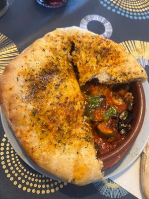 Veg in a tomato sauce baked under soft, fluffy pitta  at Paprika in Valencia