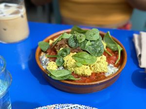 Creamy scramble and Taktouka on a Esfenaj Borani with caramalized onions and almond crackers  at DAR Restaurant & Cocktail Bar in Zurich