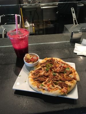 Red Head juice and a pizza with pineapple pico on the side at Thrive Juice Bar in Kitchener Waterloo