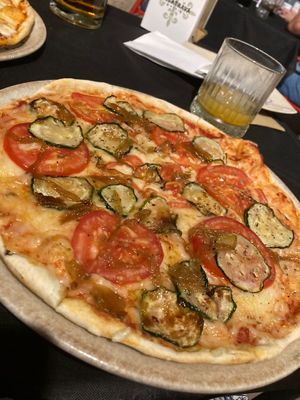 Pizza de tomate, mozzarella vegana, orégano, calabacín, cebolla caramelizada y tomate natural   at La Mia Mamma in Ciudad Real