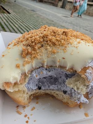 donut with white chocolate frosting, blueberry cream & macadamia nuts at Bungnuts vegan Doughnuts. in Barcelona