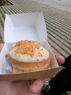 donut with white chocolate frosting, blueberry cream & macadamia nuts at Bungnuts vegan Doughnuts. in Barcelona