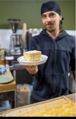 Ashley with a splendid cake   at The London Feel Good Hub Vegan Cafe in East London