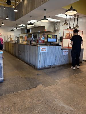 Small take out area with a few tables on the leftt  at Shouk in Rockville