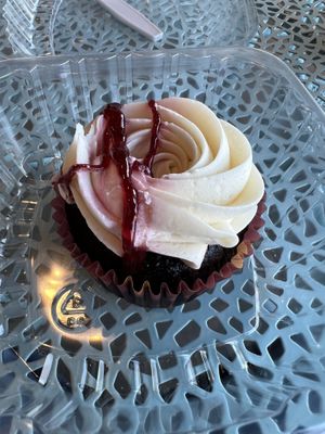 Chocolate Cupcake with vanilla frosting and raspberry drizzled on top   at The Mindful Table in Perrysburg