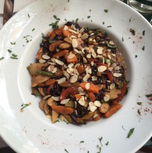 Brown rice noodles in peanut butter sauce with lots of different veggies and some blanched almonds on top at Avocado in Athens