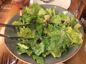 Vegan Caesar salad with a veggie twist, made with Kalamata olives, romaine lettuce, sun dried tomatoes, homemade croutons, capers, and a cashew, almond, garlic and olive oil dressing.  at Avocado in Athens