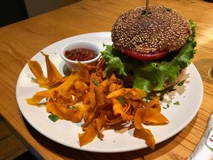 Burger with thin sweet potato fries and spicy ketchup at Avocado in Athens
